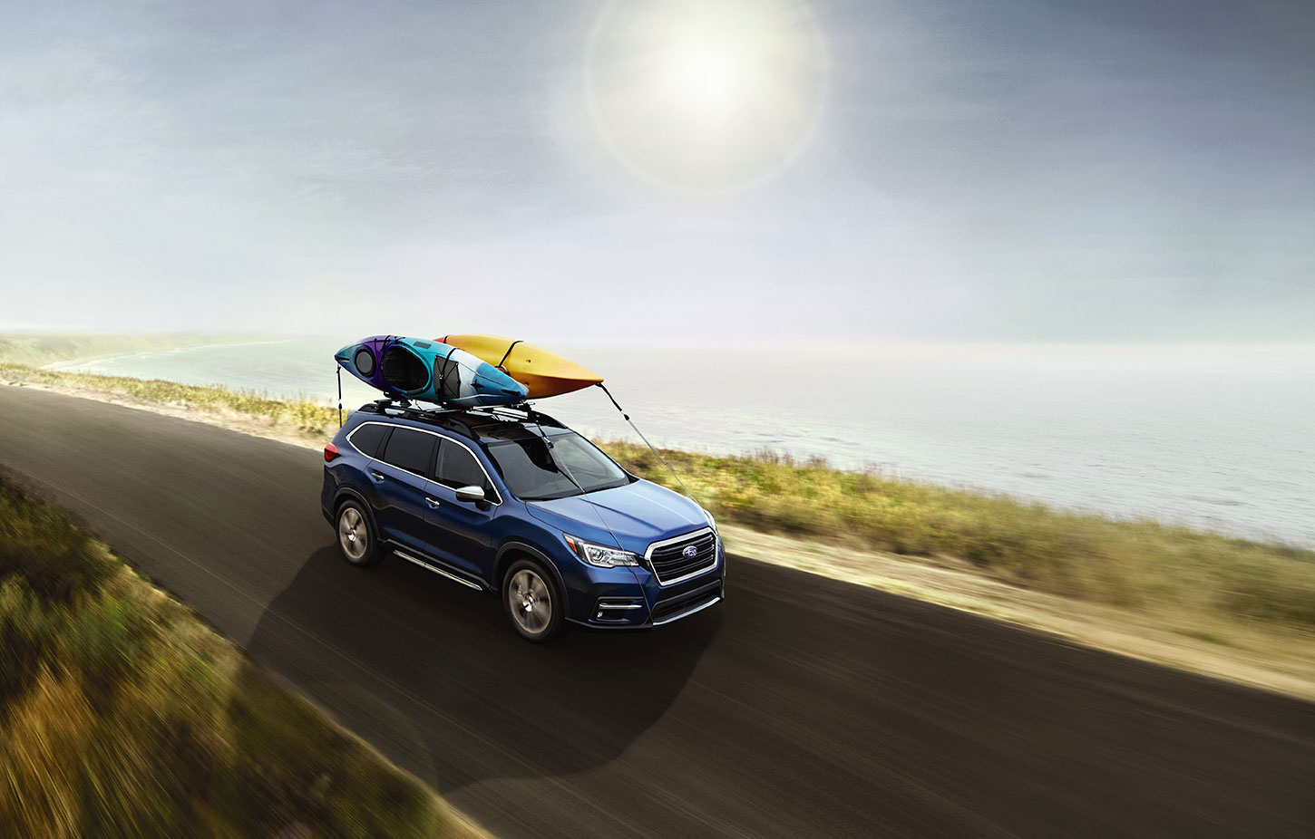 Blue Subaru Ascent with kayaks.